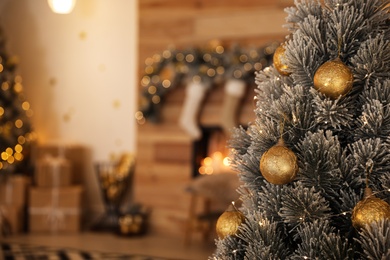 Beautiful Christmas tree decorated with balls in stylish room interior, closeup. Space for text