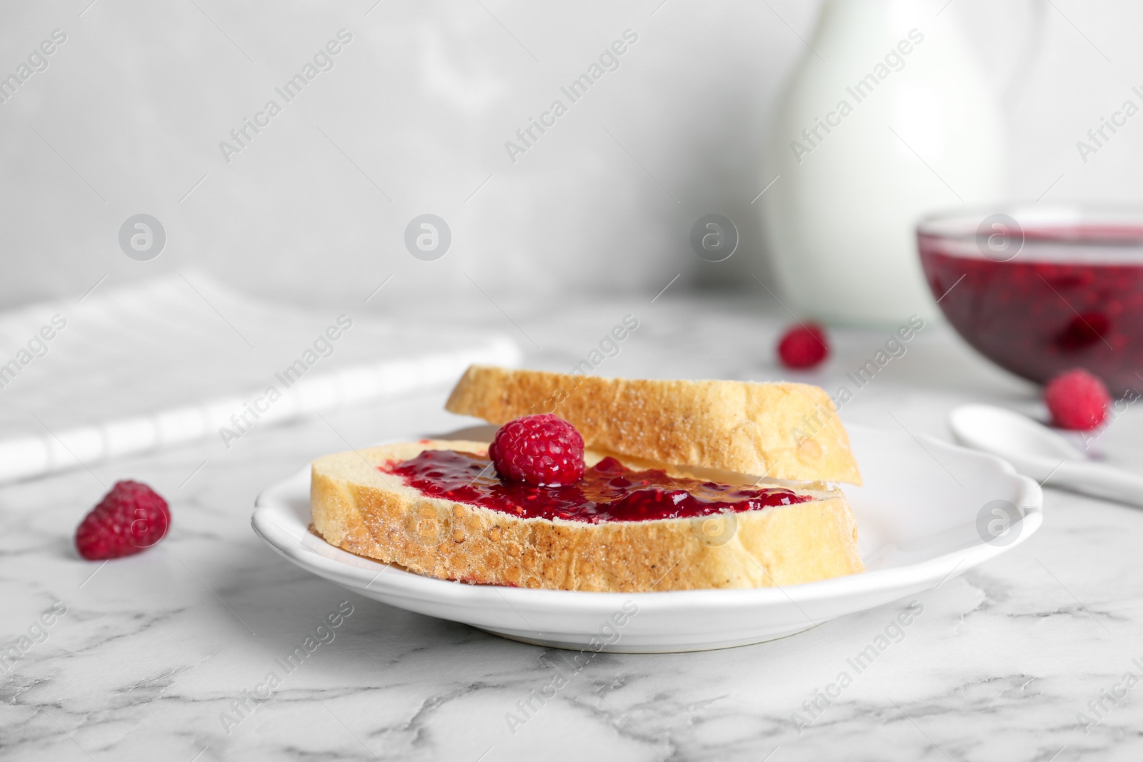 Photo of Tasty toasts with delicious raspberry jam on table