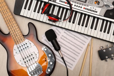 Photo of Set of different musical instruments and microphone on wooden background, flat lay