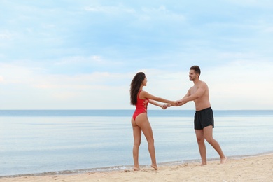 Photo of Happy young couple spending time together on beach near sea