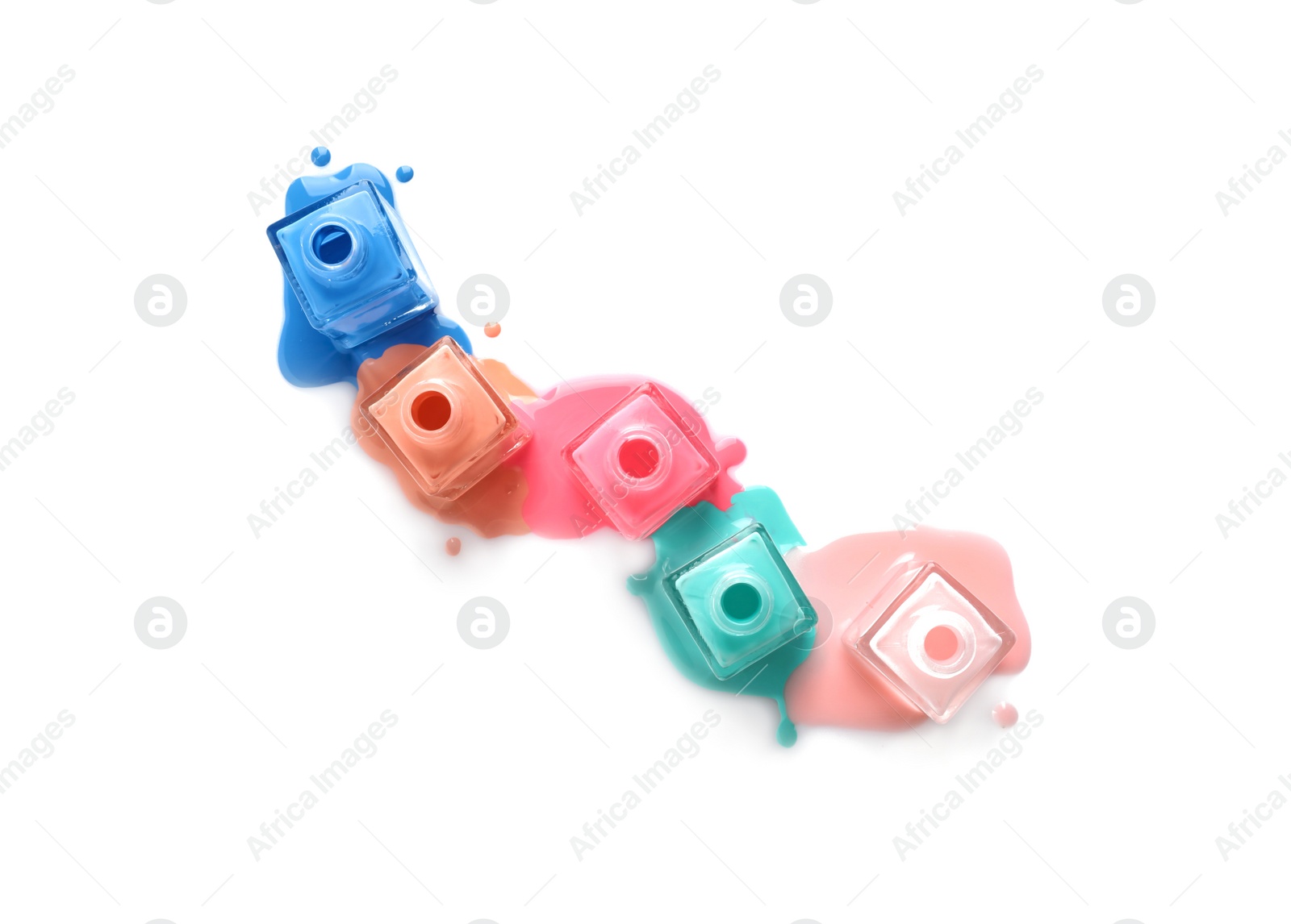 Photo of Spilled different nail polishes with bottles on white background, top view
