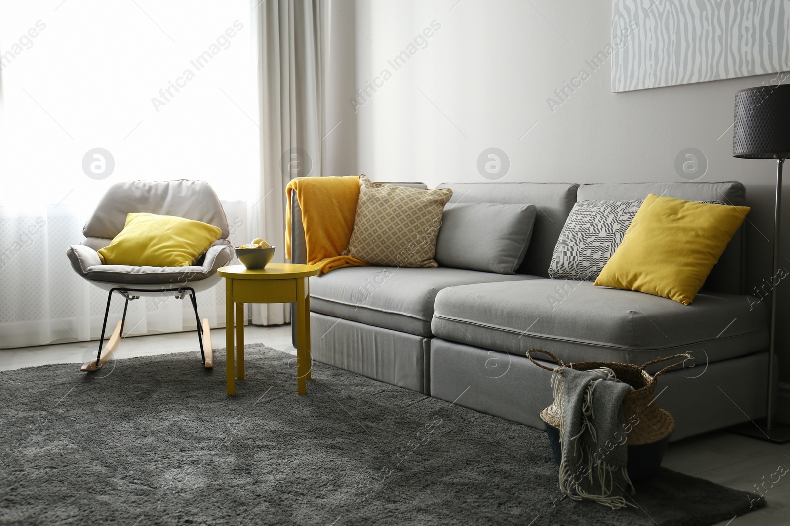 Photo of Stylish living room with sofa. Interior design in grey and yellow colors