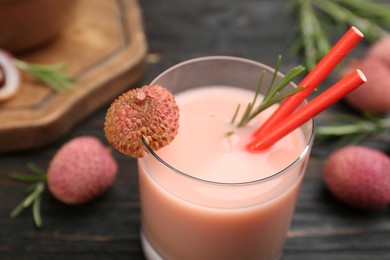 Photo of Lychee cocktail with rosemary on dark table, closeup