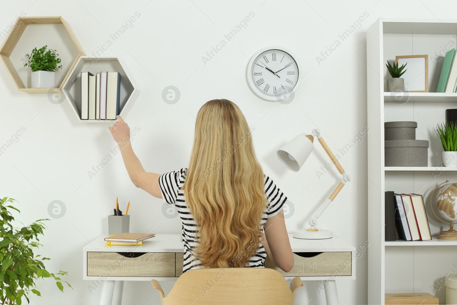 Photo of Home workplace. Woman working at comfortable desk in room, back view