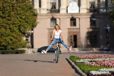 Happy woman riding bicycle outdoors on sunny day