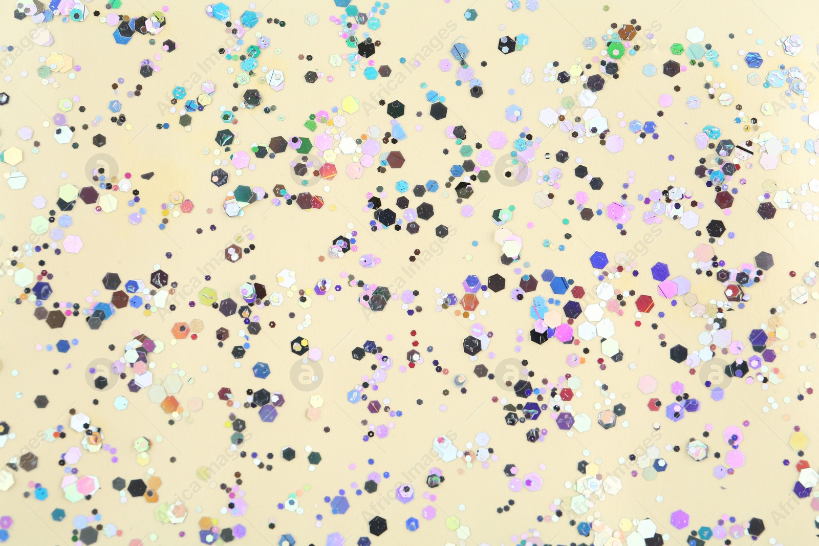 Photo of Shiny glitter on beige background, top view