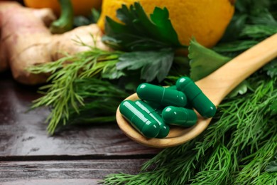 Photo of Dietary supplements. Spoon with pills and food products on wooden table, closeup