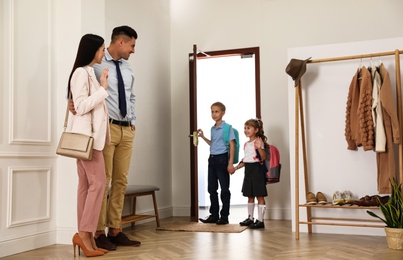 Photo of Parents with children in hallway. Getting ready for school