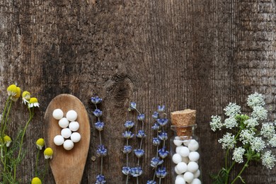 Photo of Flat lay composition with homeopathic remedy and flowers on wooden table. Space for text