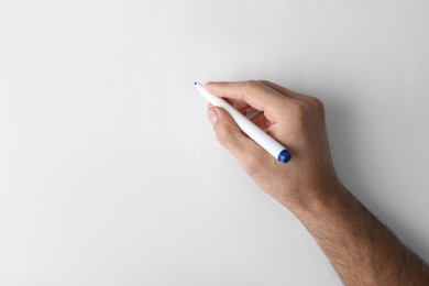 Photo of Man holding color marker on white background, top view