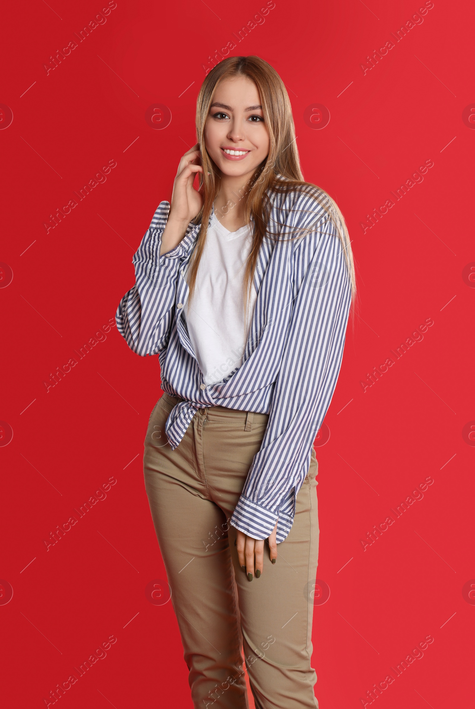 Photo of Teenage girl in casual outfit on red background