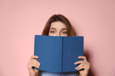 Photo of Young woman with book on color background