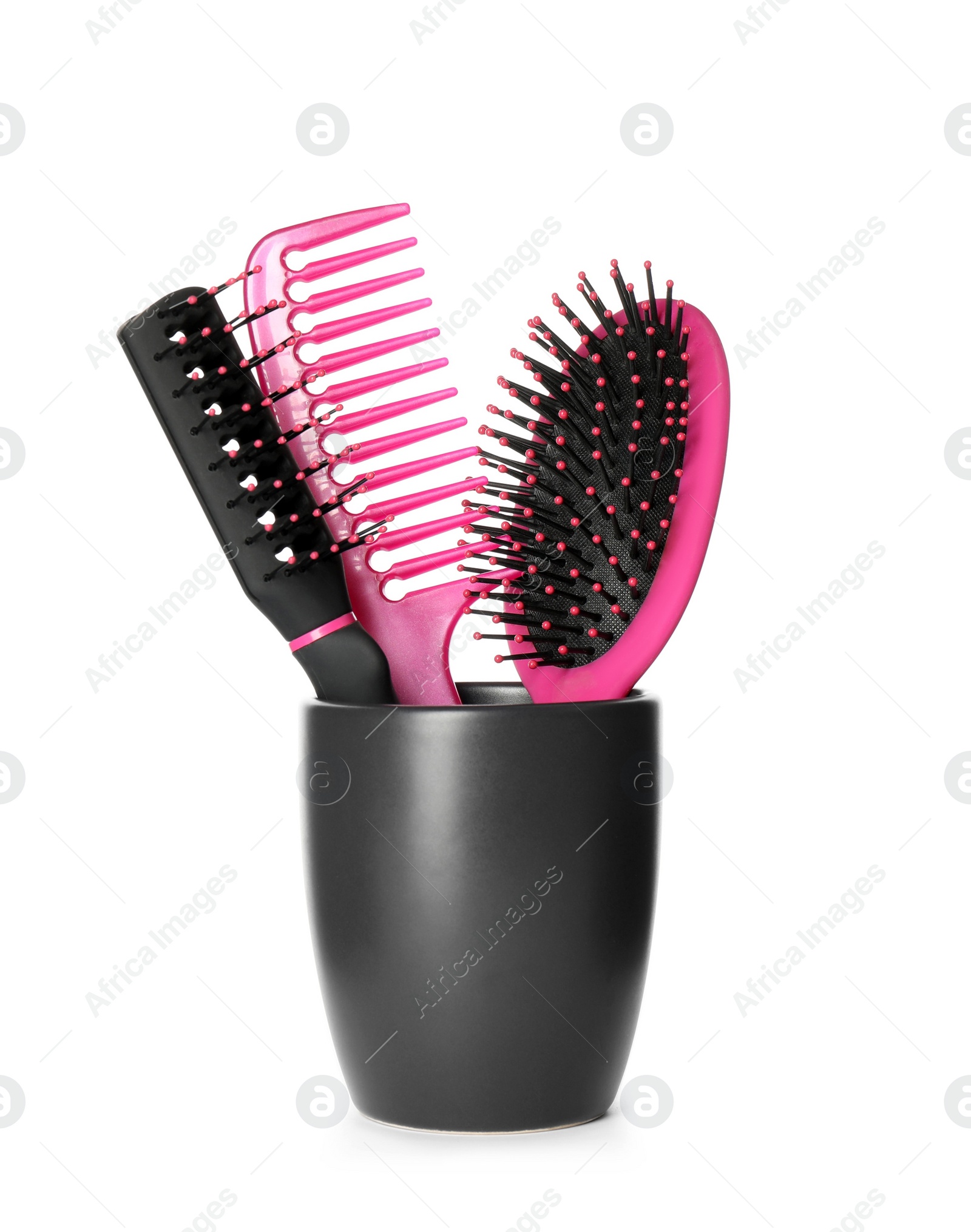 Photo of Hairbrushes and comb in holder on white background