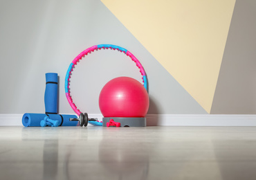 Photo of Different sports equipment near color wall in gym