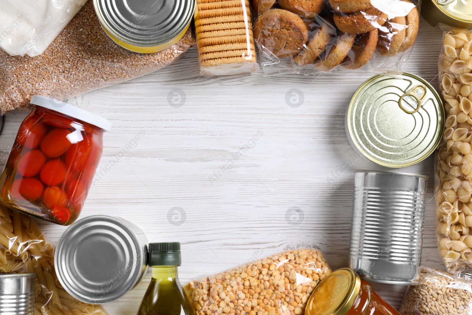 Photo of Frame of different products on white wooden table, flat lay and space for text. Food donation