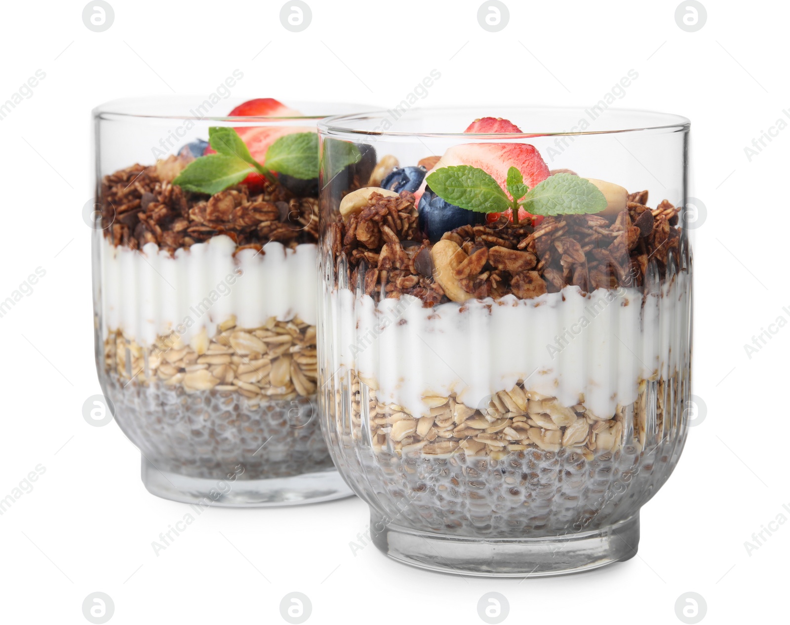 Photo of Tasty granola with berries, nuts, yogurt and chia seeds in glasses isolated on white