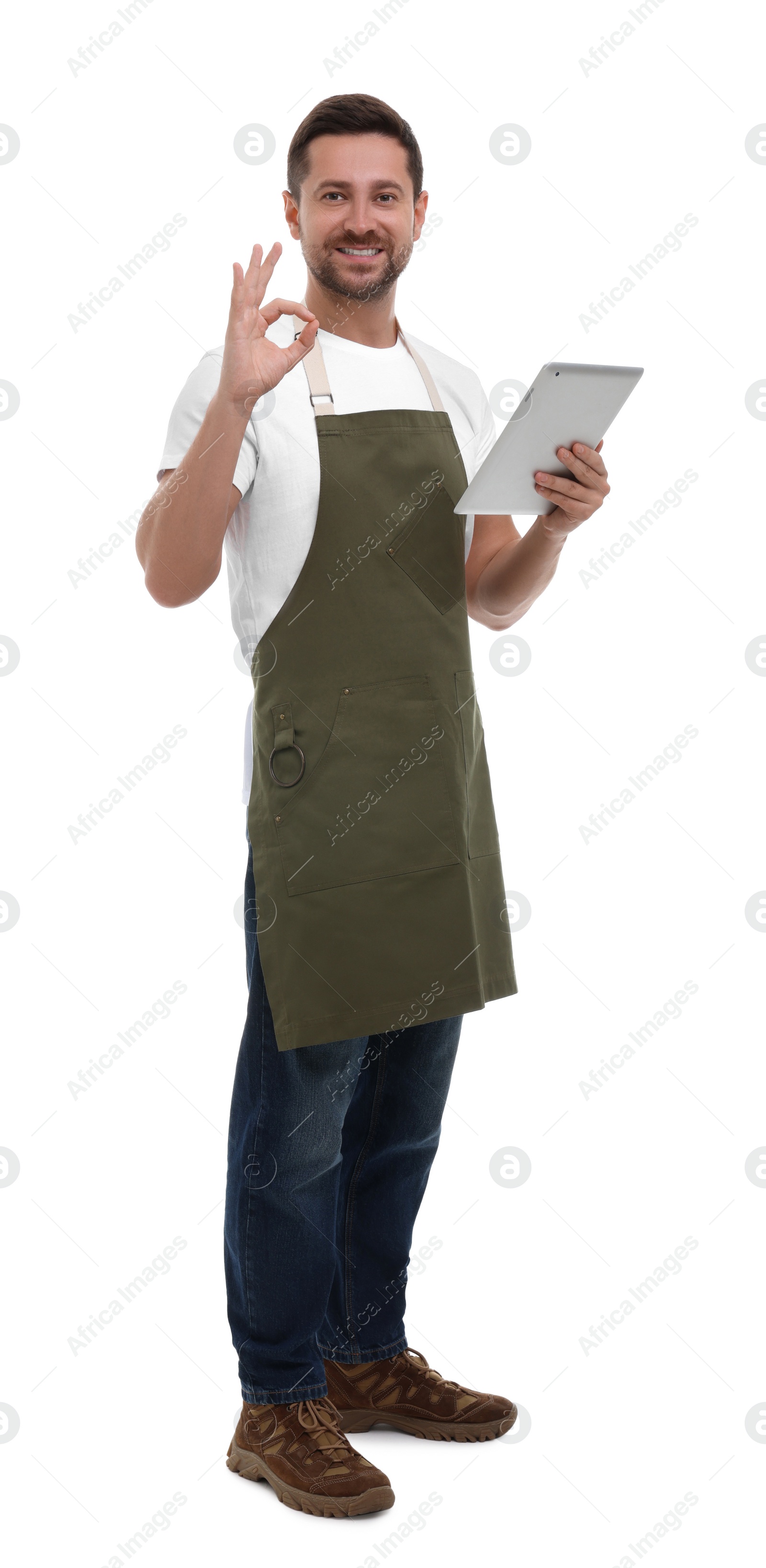 Photo of Smiling man with tablet showing ok gesture on white background