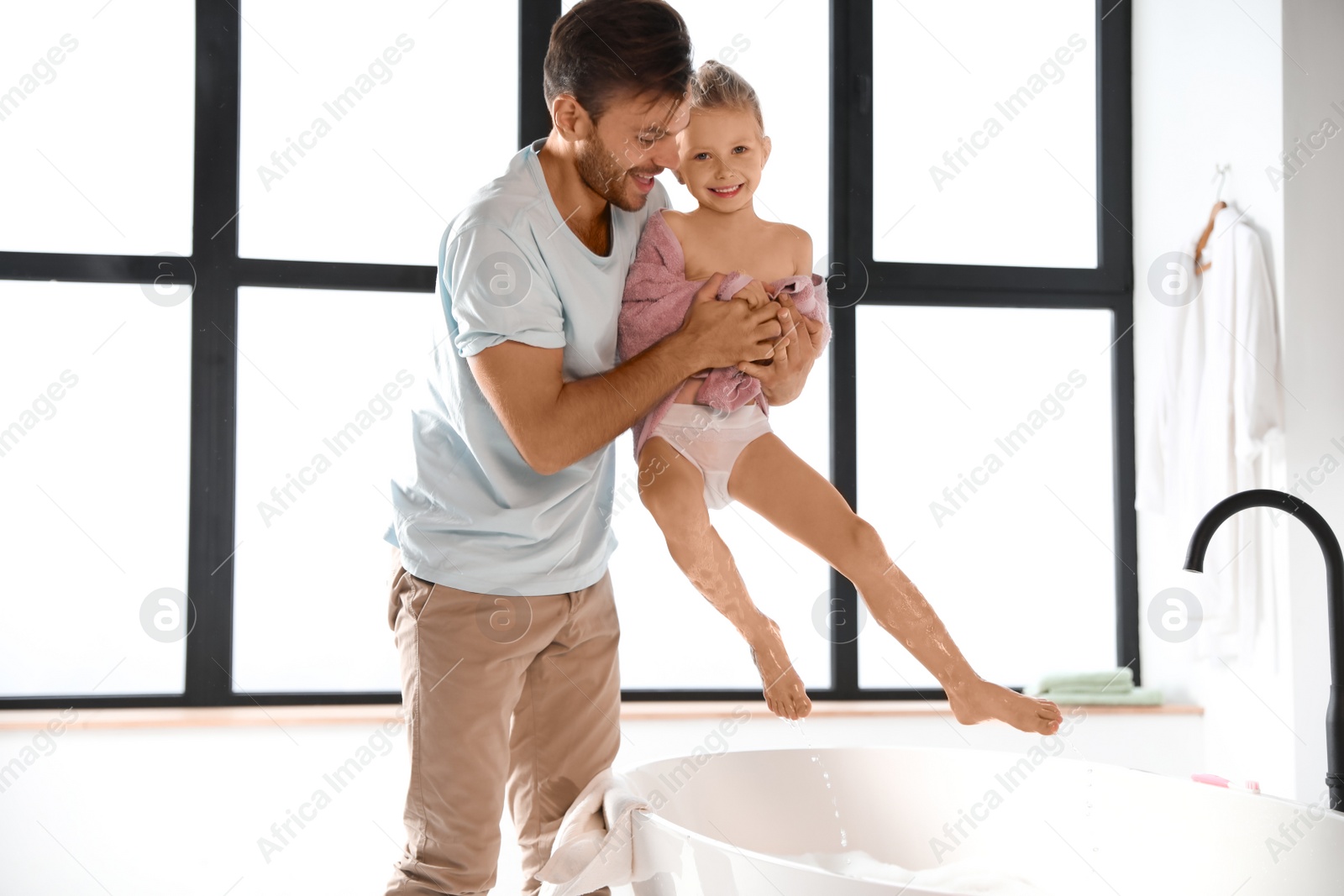 Photo of Father and his cute little daughter in bathroom