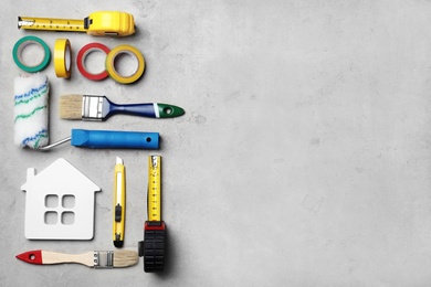 Photo of Set of decorator's tools on grey background, flat lay