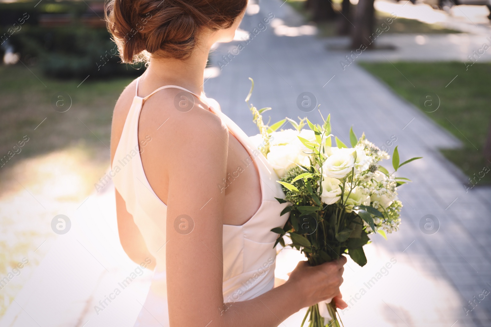 Photo of Bride in beautiful wedding dress with bouquet outdoors, closeup