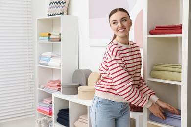 Photo of Smiling young woman choosing bed linens in shop. Space for text