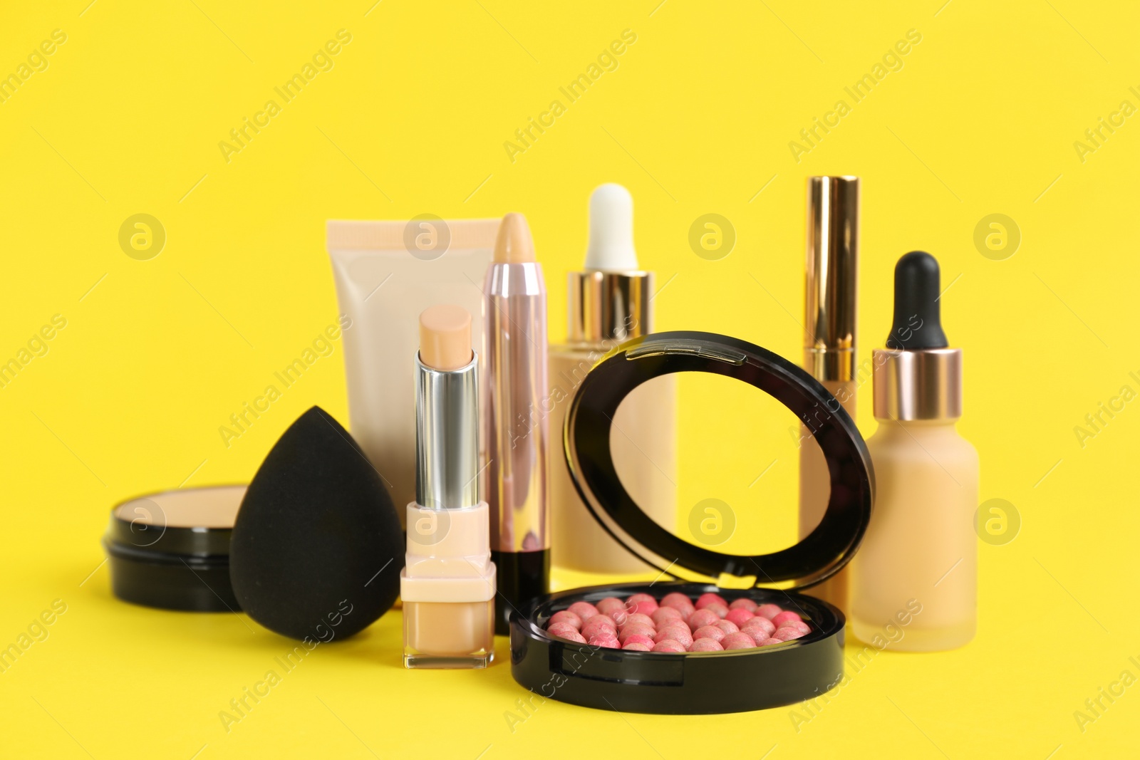 Photo of Foundation makeup products on yellow background. Decorative cosmetics