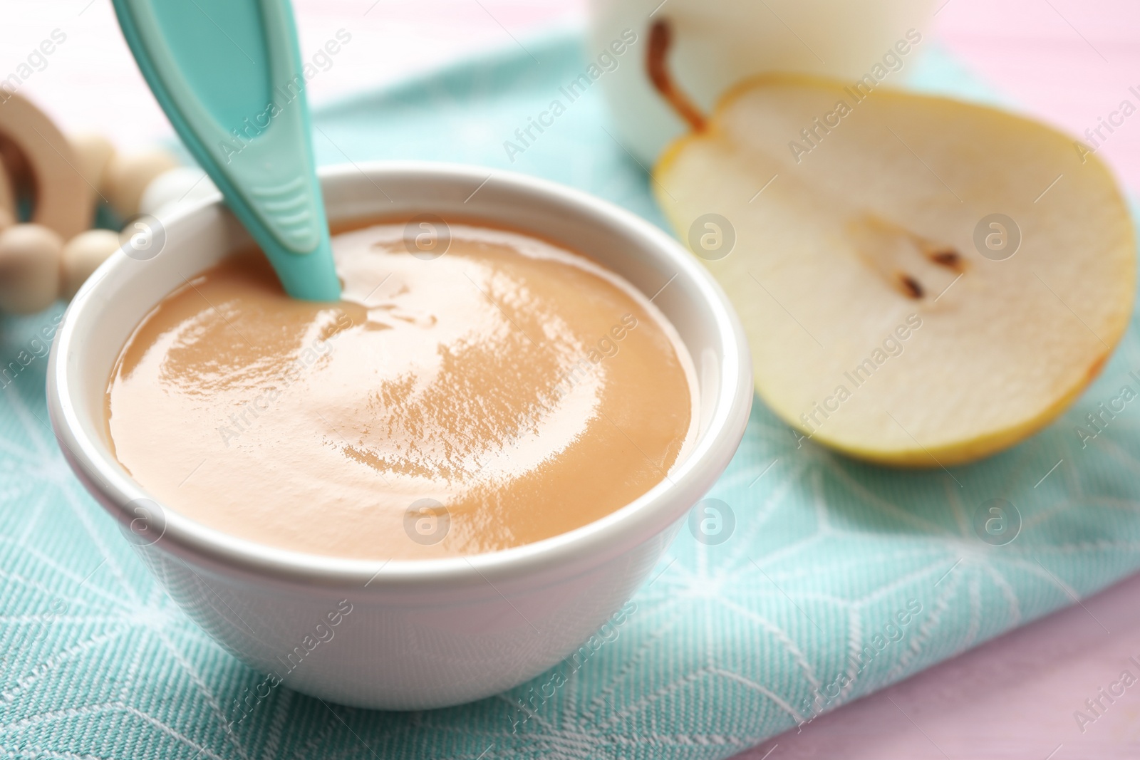 Photo of Bowl of healthy baby food on pink table, closeup. Space for text