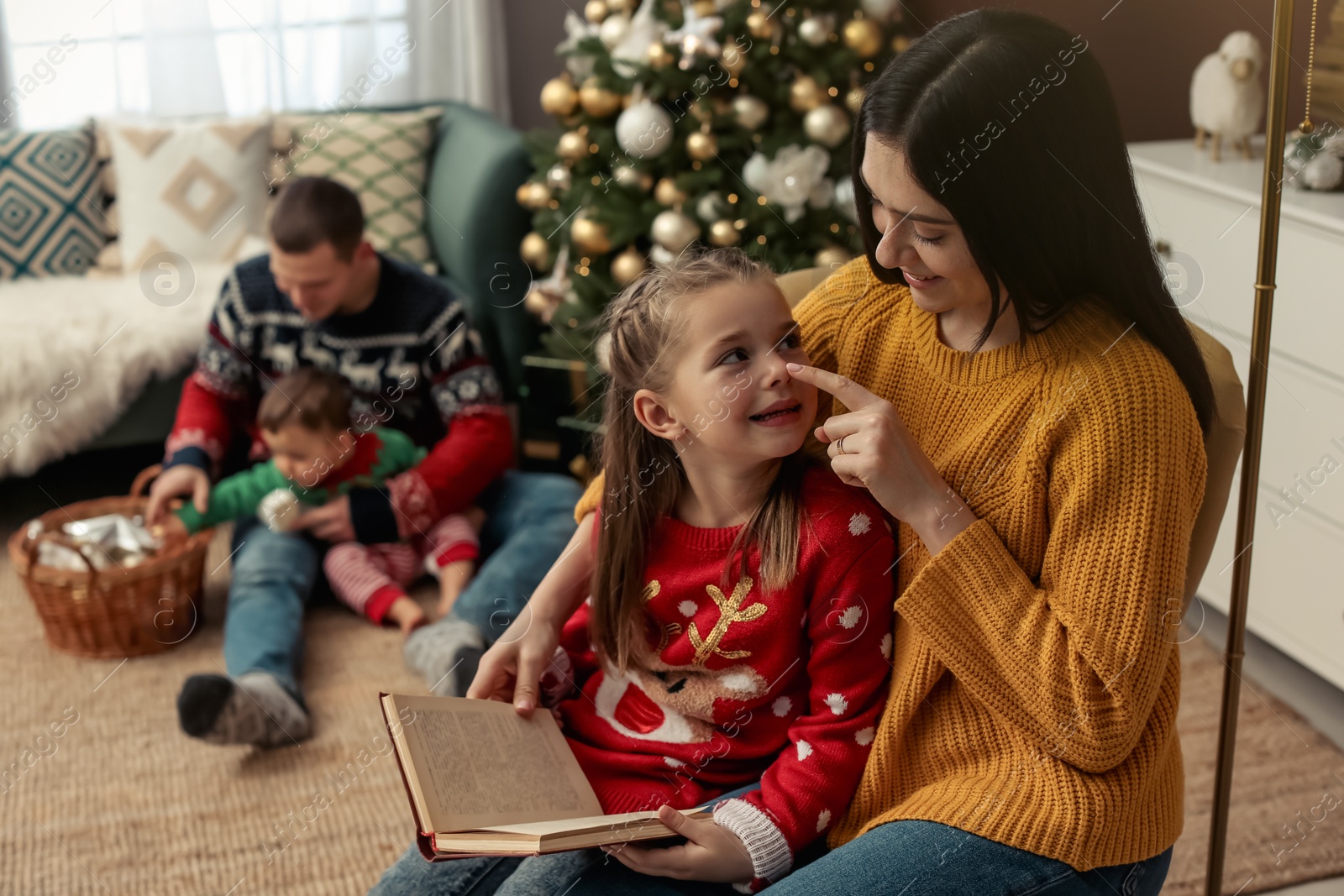 Photo of Happy family spending time together in room decorated for Christmas