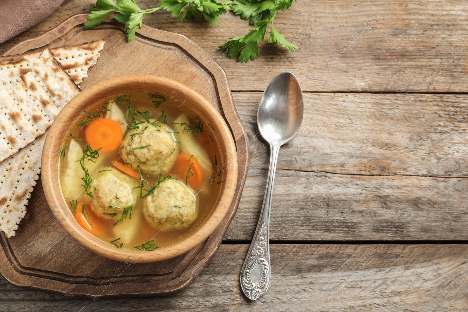 Photo of Flat lay composition with Jewish matzoh balls soup on wooden table. Space for text