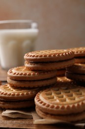 Photo of Tasty sandwich cookies with cream on wooden table, closeup