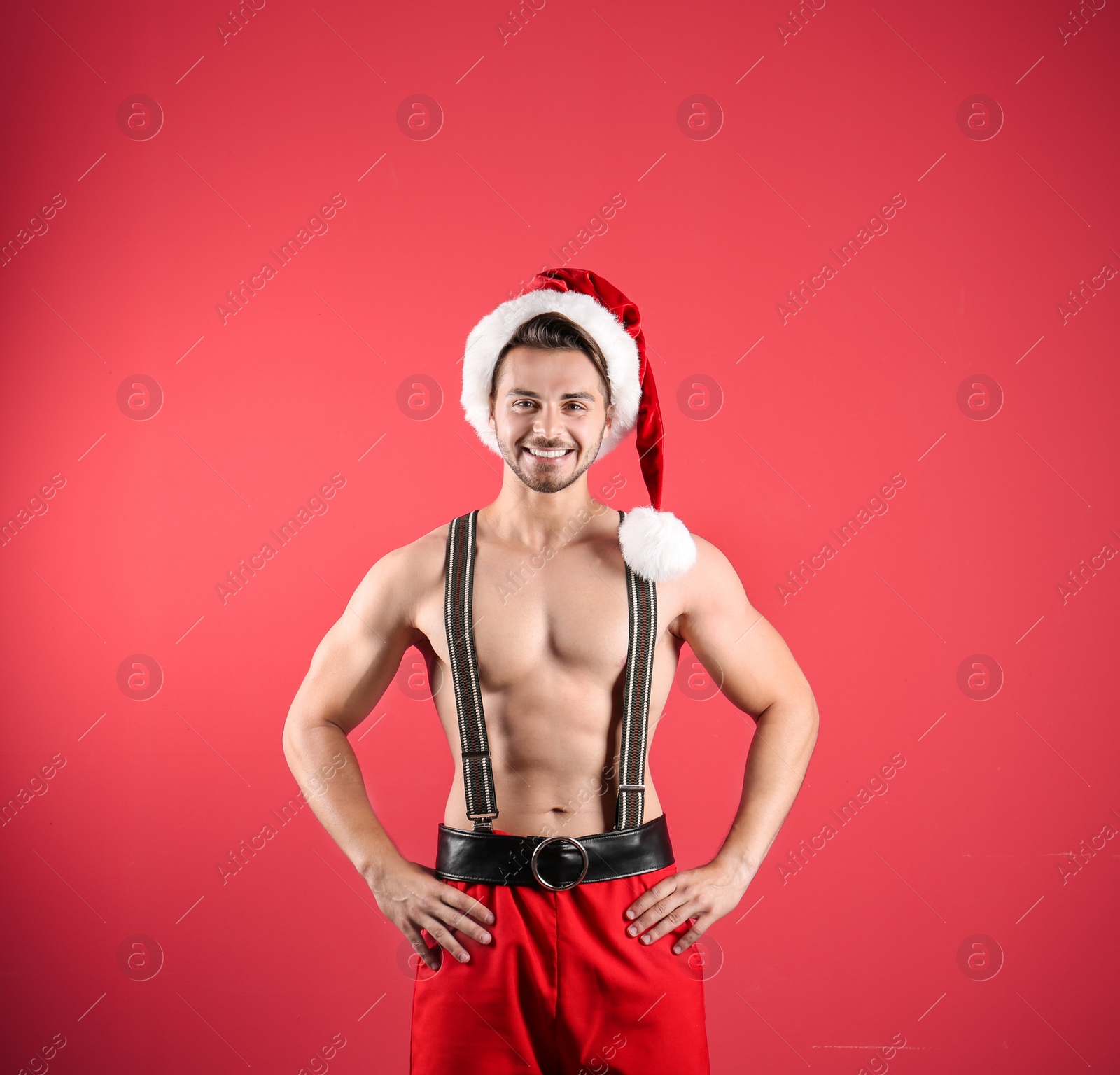 Photo of Shirtless young Santa Claus with sexy body on color background