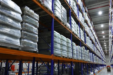 Photo of Warehouse interior with metal racks fullmerchandise. Wholesale business
