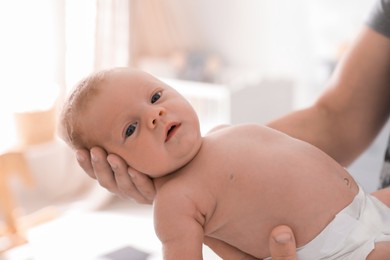 Photo of Father holding his little baby in bedroom