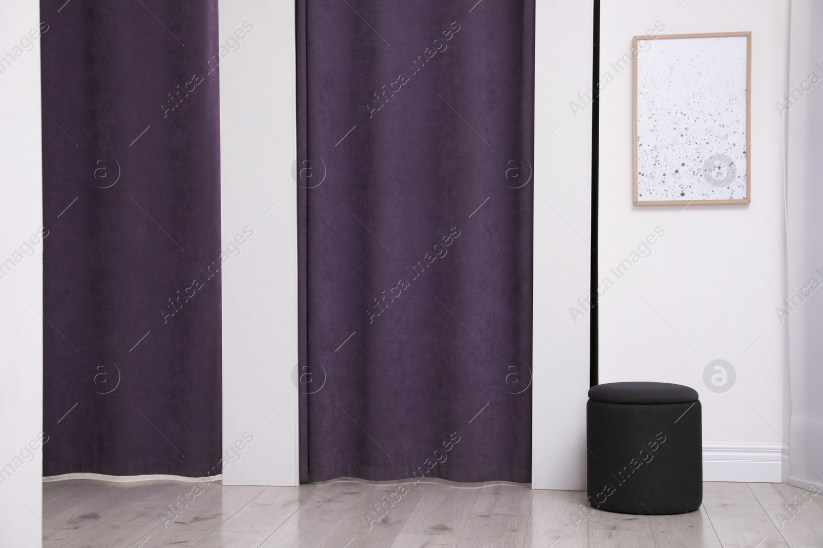 Photo of Dressing rooms with stylish purple curtains in fashion store