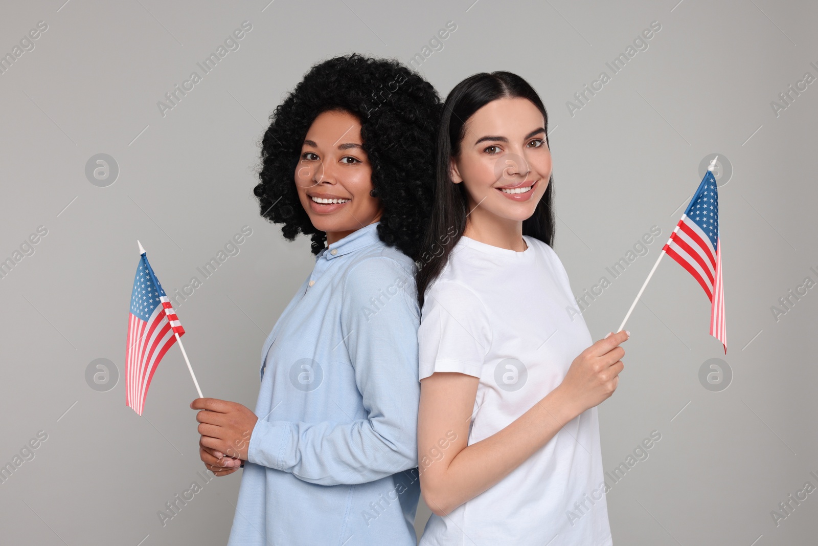 Photo of 4th of July - Independence Day of USA. Happy women with American flags on grey background