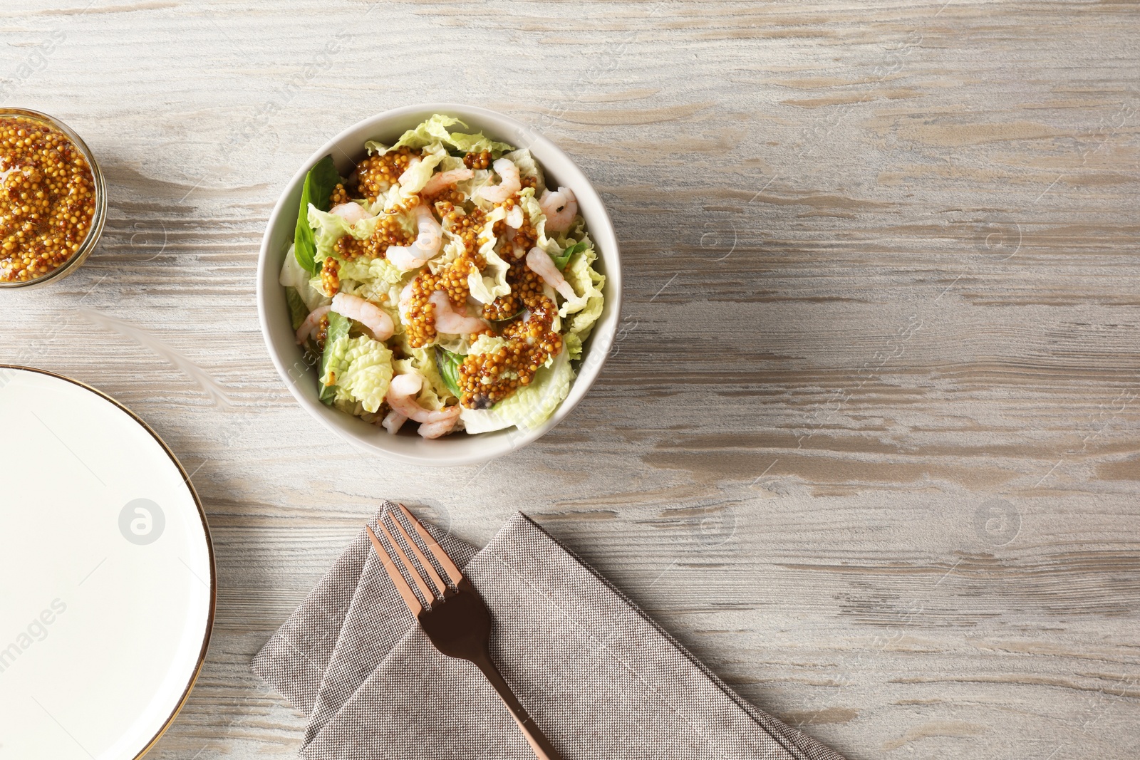 Photo of Delicious salad with Chinese cabbage, shrimps and mustard seed dressing served on white wooden table, flat lay. Space for text