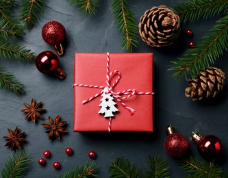 Flat lay composition with beautiful gift box and different Christmas decor on dark background