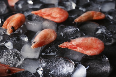 Photo of Shrimps and ice cubes on table, closeup