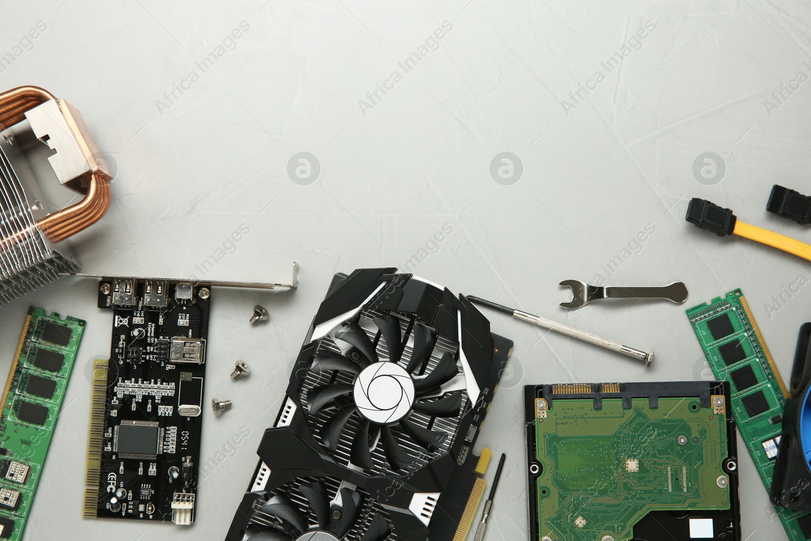 Photo of Graphics card and other computer hardware on gray textured background, flat lay. Space for text