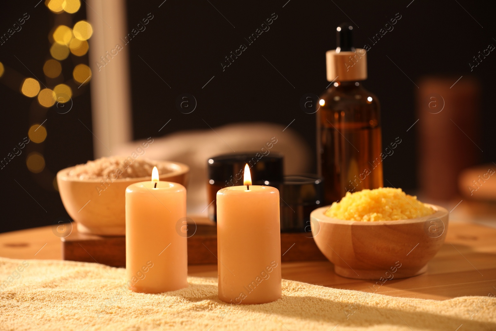 Photo of Spa composition with burning candles and personal care products on soft light surface