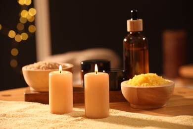 Photo of Spa composition with burning candles and personal care products on soft light surface