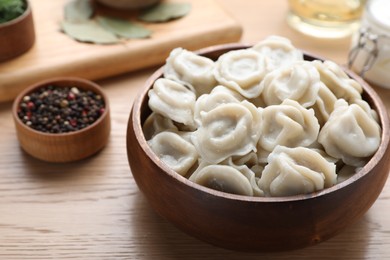 Photo of Tasty dumplings in bowl on wooden table, closeup