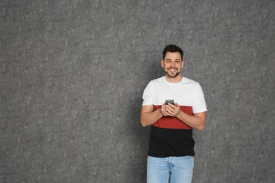 Photo of Portrait of man with mobile phone against grey background. Space for text