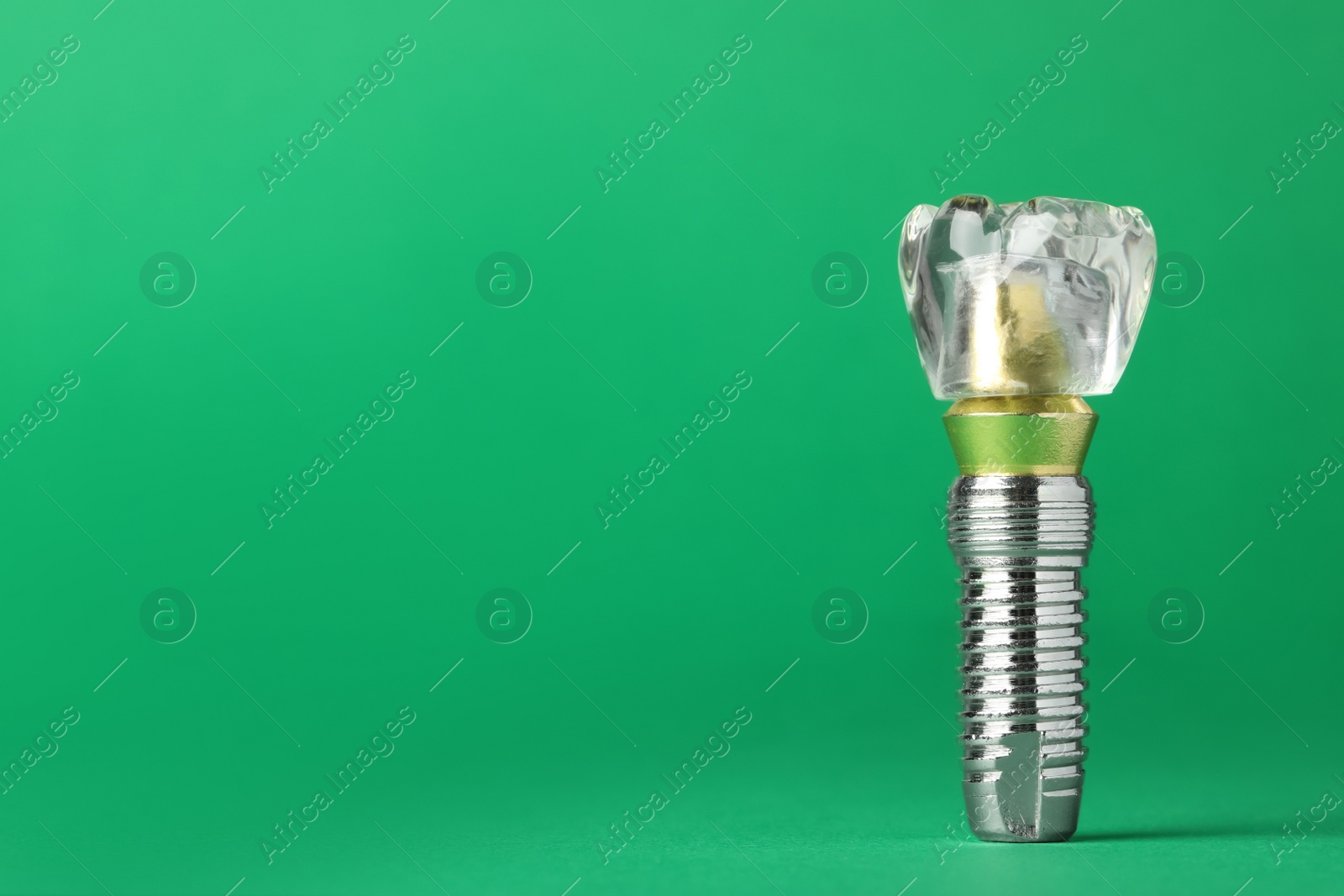 Photo of Educational model of dental implant on green background. Space for text