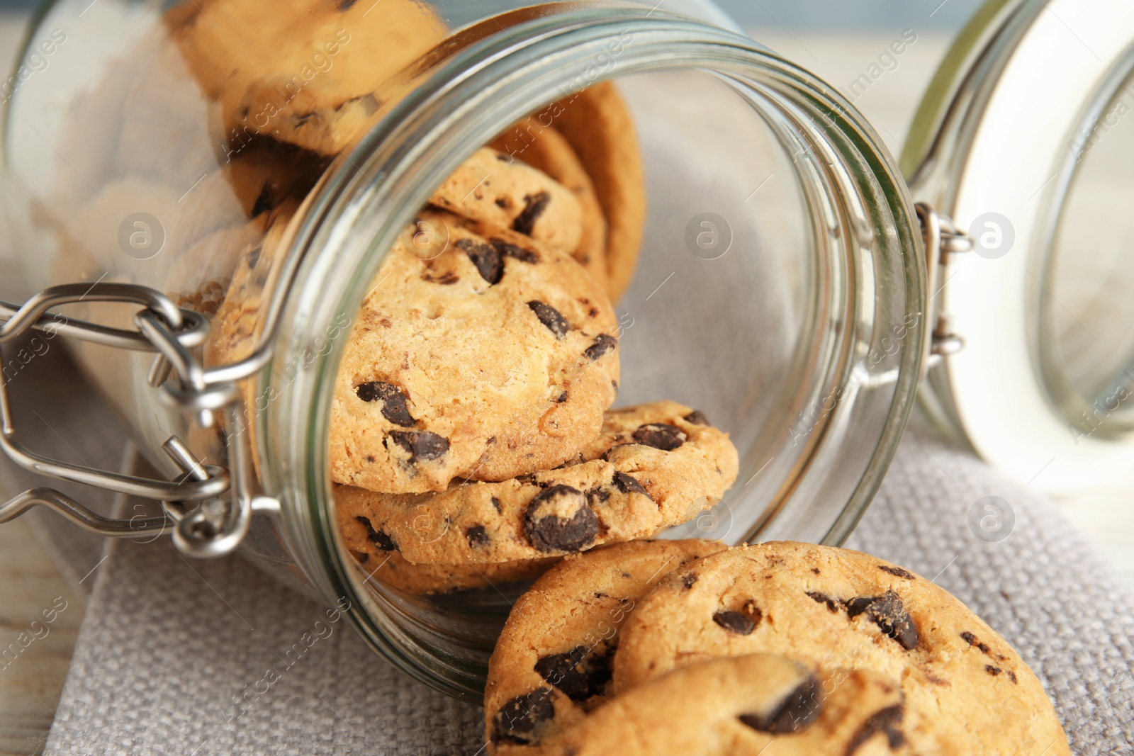 Photo of Jar of tasty chocolate chip cookies on table