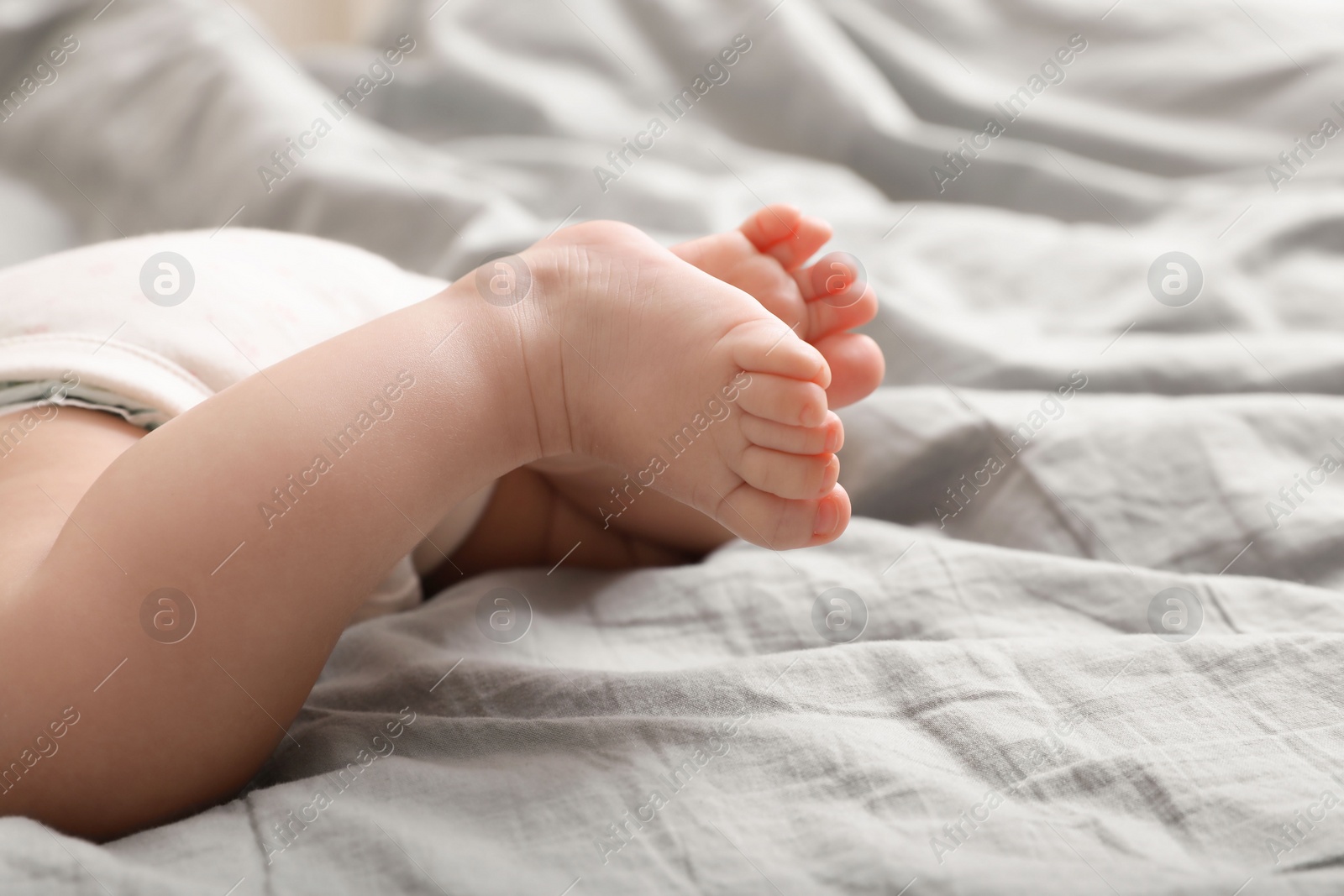 Photo of Little baby lying on bed, closeup view