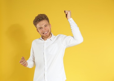 Portrait of handsome emotional man on color background