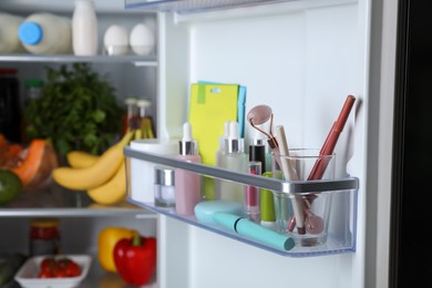 Photo of Storage of cosmetics and tools in refrigerator door bin next to groceries