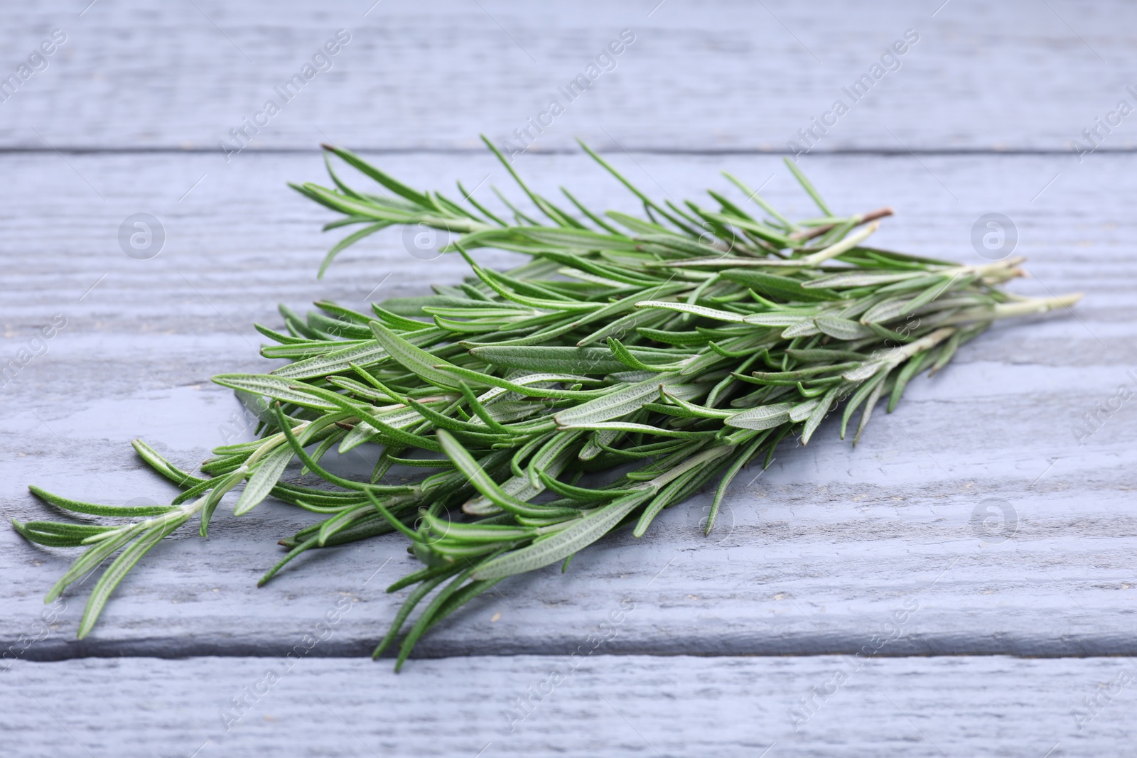 Photo of Sprigs of fresh rosemary on wooden table