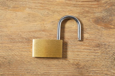 Photo of Steel padlock on wooden table, top view